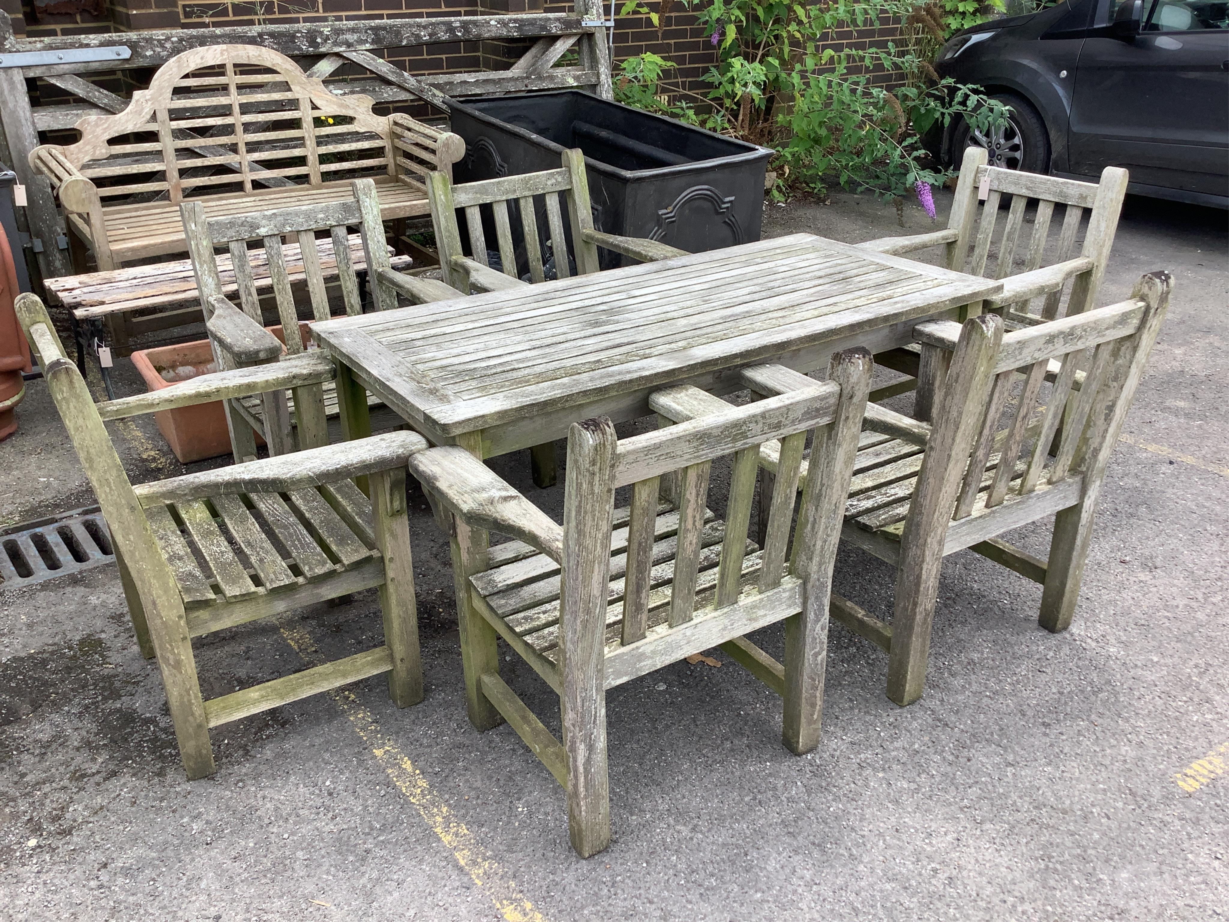 A rectangular weathered teak garden table, width 164cm, depth 79cm, height 70cm, together with a set of six weathered teak armchairs. Condition - fair
